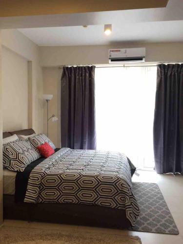 a bedroom with a bed and a large window at 1BR Condo Unit in Pico De Loro in Nasugbu