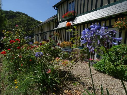 a garden in front of a house with flowers at Chambre d'hôtes Au Fil De L'eau in Jumièges