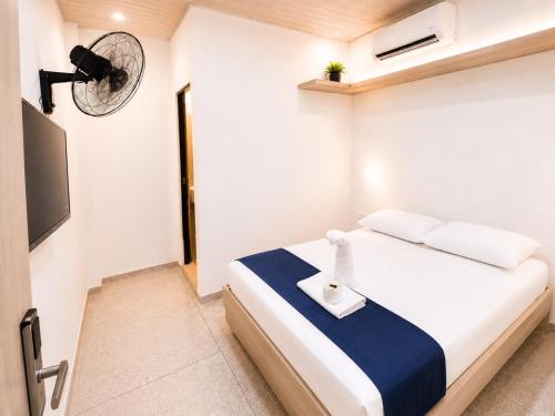 a small bedroom with a bed with a fan at hotel venus in Los Patios