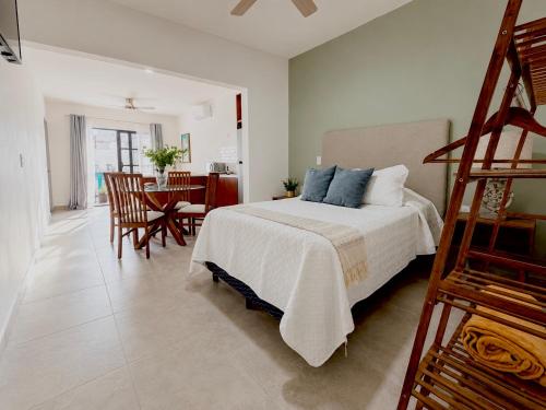 a bedroom with a bed and a dining room with a table at Casa DOS21 Boutique Apartments Playa Sur in Mazatlán