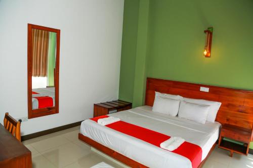 a bedroom with a large bed with a mirror at Sea Cloud Dalawalle in Unawatuna