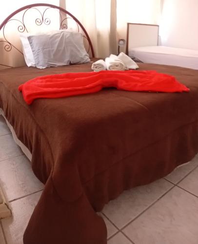 a bed with a red blanket on top of it at Apto completo centro in Rio Grande