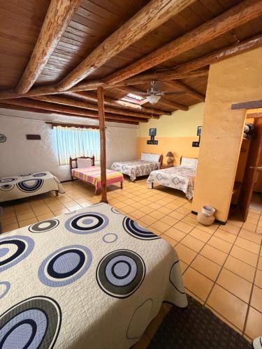 a large room with two beds in a room at Hotel Paraiso del Oso in Cerocahui
