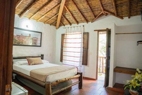 a bedroom with a bed in a room with a window at Hotel Boutique Macaregua Girón in Girón