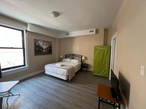a bedroom with a bed and a table and a window at Bauer Guesthouse in Toronto