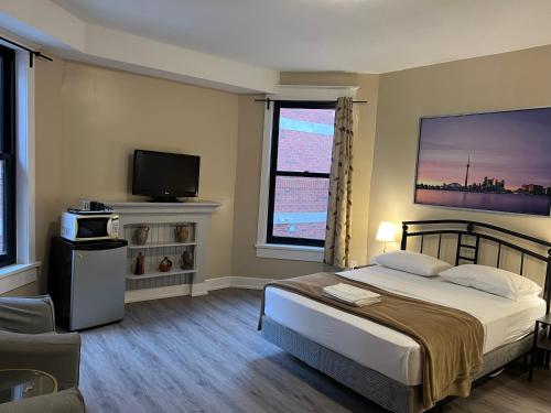 a bedroom with a large bed and a television at Bauer Guesthouse in Toronto