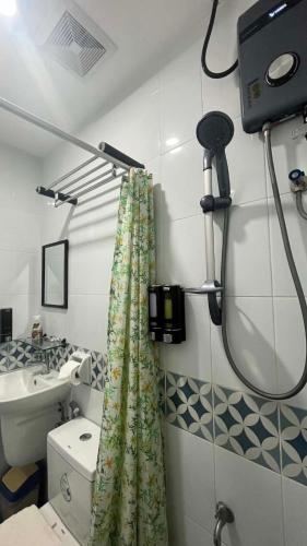 a bathroom with a shower curtain and a sink at Mamma Rose Hotel in Legazpi