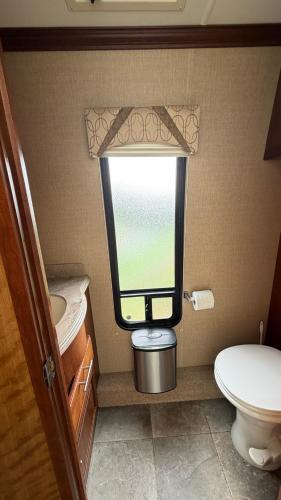 a small bathroom with a toilet and a window at Maggies Place in Ingonish