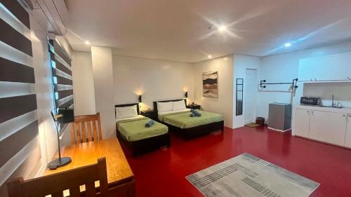 a living room with two beds and a kitchen at Mamma Rose Hotel in Legazpi
