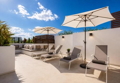a patio with chairs and umbrellas at Magico s apartments in Playa del Carmen