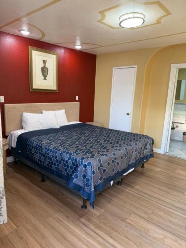 a bedroom with a bed in a room with red walls at Penguin Motel in Harbor City