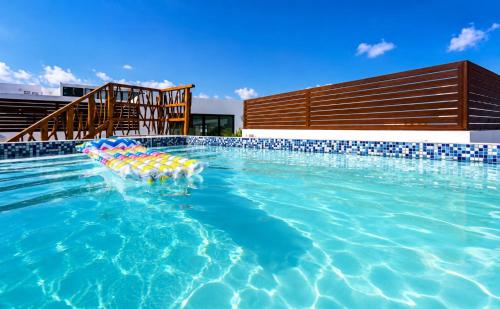 a swimming pool with lounge chairs in the water at Magico s apartments in Playa del Carmen