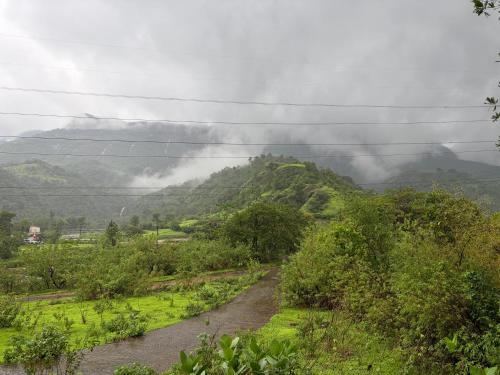 a dirt road in front of a mountain at Prince Villa in Neral