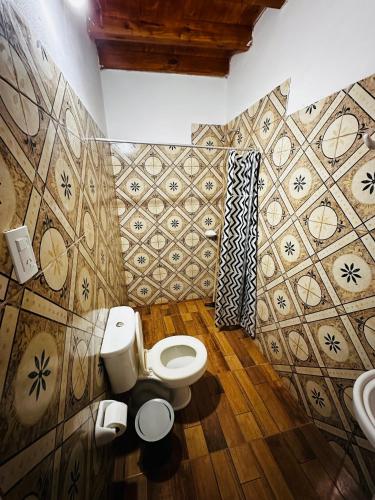 a bathroom with a toilet and a sink at Salvita Hospedaje y Excursiones in El Peñón