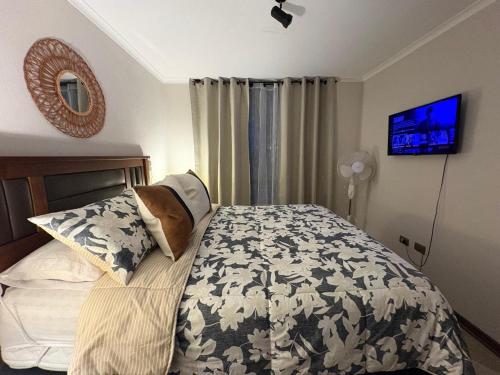 a bedroom with a bed with a black and white comforter at Hermoso depto. con estacionamiento in Los Ángeles