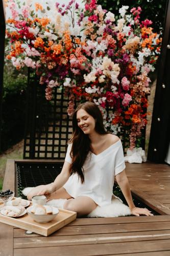 a woman sitting on a table in front of flowers at Cabana Veneza in Santa Teresa
