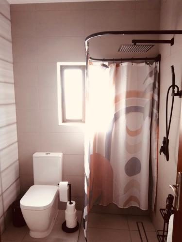 a bathroom with a toilet and a shower curtain at Casa de Cima in Doze Ribeiras