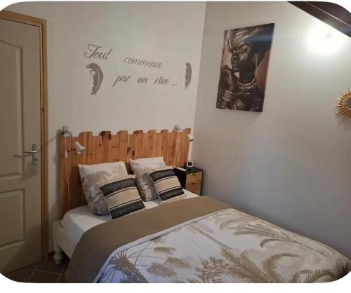a bedroom with a bed and a sign on the wall at Chalet "Le Boisé" in Les Abymes