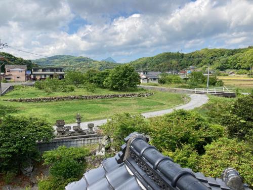 a view of a field and a road with mountains at くりのやかた Kuri no Yakata in Minami-ura