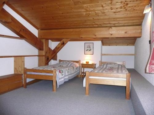 two beds in a room with wooden ceilings at Saint-Roch Piste in Val dʼIsère