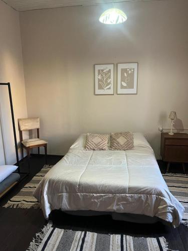 a bedroom with a large bed and a chair at disfruta tu estadía in Salto
