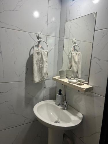 a white bathroom with a sink and a mirror at disfruta tu estadía in Salto