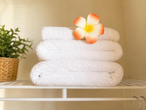 a stack of towels with a flower on a shelf at Balloons and Wine in Murrieta