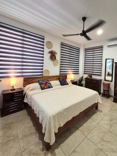a bedroom with a large bed with a ceiling fan at Sicarú, La Punta - Puerto Escondido in Brisas de Zicatela