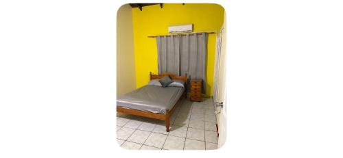 a small bedroom with a bed and a yellow wall at Ocean veiw Apartment in Telescope