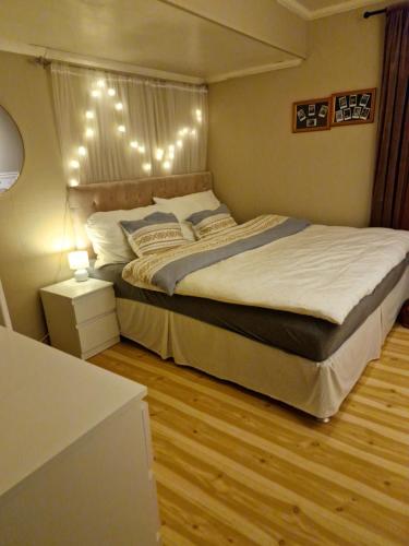 ein Schlafzimmer mit einem großen Bett mit Beleuchtung in der Unterkunft Løten in Løten