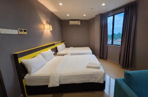 a hotel room with two beds and a window at Kampar Boutique Hotel in Kampar