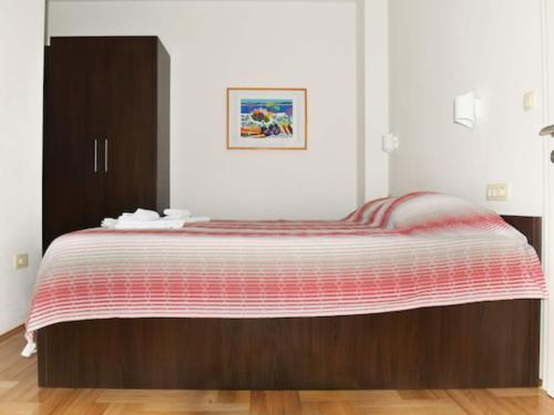 a bedroom with a bed with a red and white blanket at Apartments Despot Zaostrog RC in Zaostrog