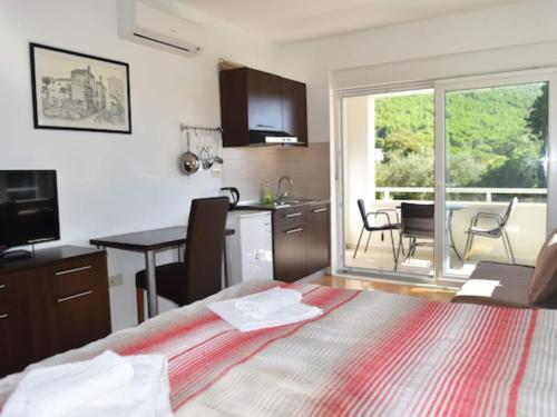 a bedroom with a bed and a kitchen with a table at Apartments Despot Zaostrog RL in Zaostrog