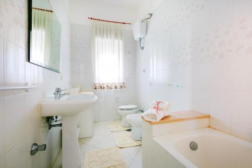a white bathroom with a sink and a toilet at Casa al Belvedere in Vico Equense