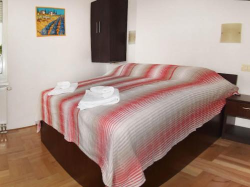 a bedroom with a bed with a striped blanket at Apartments Despot Zaostrog RR in Zaostrog