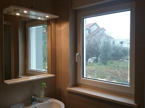 a bathroom with a sink and a large window at Apartments Despot Zaostrog RO in Zaostrog