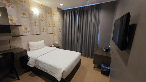 a hotel room with a bed and a television at Kampar Boutique Hotel in Kampar
