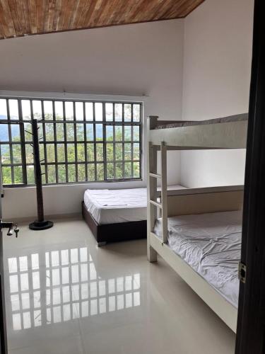 a bedroom with two bunk beds and two windows at San Gerónimo Casa Hostal in Mocoa