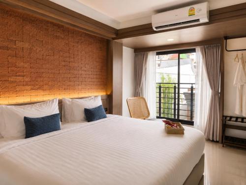 a bedroom with a large bed and a window at Wangkaew Hotel, Phitsanulok in Phitsanulok