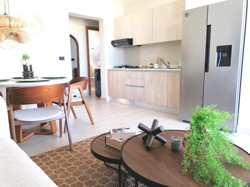 a kitchen and living room with a table and a refrigerator at Green Oasis - Dominicus, Bayahibe in La Laguna