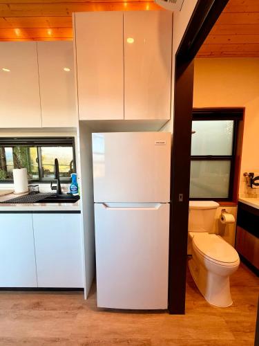 a kitchen with a white refrigerator and a toilet at Hilltop View Sanctuary in Fallbrook