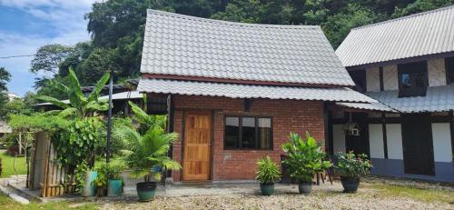 a small brick house with a wooden door at Bamboo Cottage Langkawi in Pantai Cenang