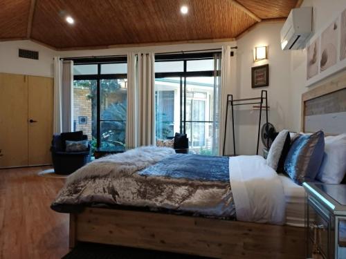 a bedroom with a large bed and a large window at Garden Suite, self contained, Hunter Valley in Muswellbrook