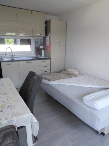 a bedroom with a bed and a kitchen with a sink at Apartma Sonček in Šentjur