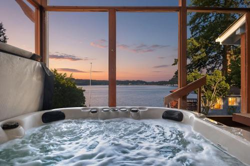a bath tub with a view of the water at Phenomenal Sunsets Wild Orca & Private Beach in Shelton