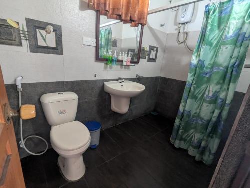 a bathroom with a toilet and a sink at Ocean Haven in Induruwa
