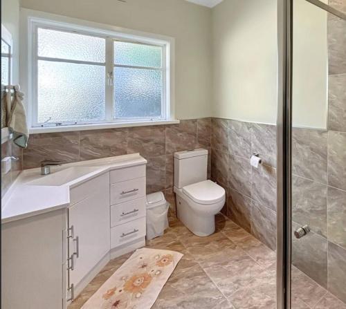 a bathroom with a toilet and a sink and a shower at Your gateway to the Lakes in Bairnsdale