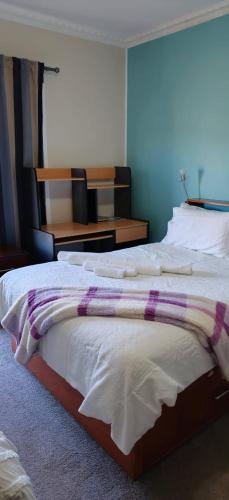 a bedroom with a bed with a purple and white blanket at Your gateway to the Lakes in Bairnsdale