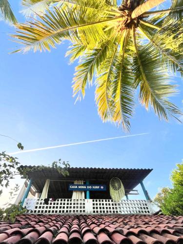 a palm tree over the roof of a building at Surf e Café in Cabo de Santo Agostinho