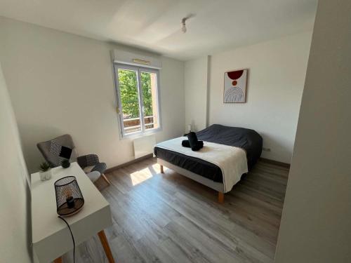 a bedroom with a bed and a desk and a window at La Petite Citadine Proche Futuroscope in Poitiers